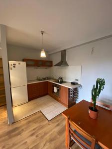 a kitchen with a table and a white refrigerator at Murano Apartaments Nova Praga in Warsaw