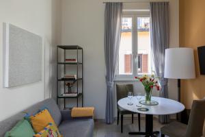 een woonkamer met een bank, een tafel en een raam bij Now Apartments, ApartHotel in the heart of Rome in Rome