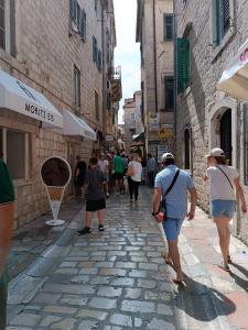 a group of people walking down a street at Nova dvokrevetna soba sa dva odvojena kreveta i zajedničkim kupatilom in Kotor