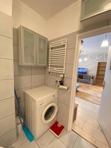 a bathroom with a washing machine in a room at Murano Apartaments Nova Praga in Warsaw