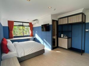 a bedroom with blue walls and a bed and a window at Penpark Place in Bangkok