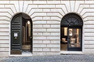 twee gebogen ramen van een bakstenen gebouw met een zwarte deur bij Now Apartments, ApartHotel in the heart of Rome in Rome