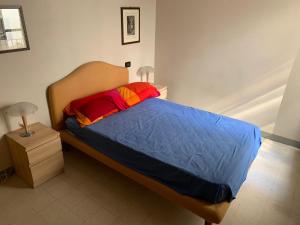 um quarto com uma cama com um edredão azul e 2 candeeiros em Appartamento in centro storico a Lucca em Lucca