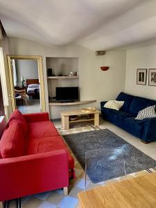 ein Wohnzimmer mit einem roten Sofa und einem blauen Sofa in der Unterkunft Appartamento in centro storico a Lucca in Lucca