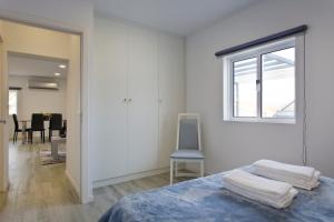 a bedroom with a bed and a window and a chair at Casa de Cristelos in Lousada