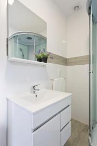 a white bathroom with a sink and a shower at Casa de Cristelos in Lousada