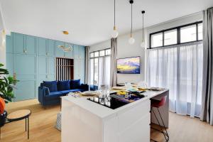 Il comprend une cuisine et un salon doté d'un canapé bleu. dans l'établissement CMG - Magnifique appartement-Saint-Germain/Bon marché - Paris 7eme, à Paris