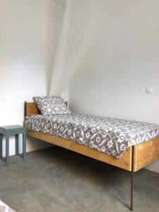 Cama de madera en habitación con cortina en Casa Palmeira, en Lazareto