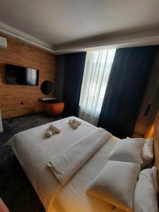 1 dormitorio con 1 cama grande con sábanas y almohadas blancas en A8 b&b, en Zagreb