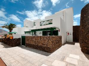 a white building with a fence in front of it at Apartamento Maëlle Playa Blanca in Playa Blanca