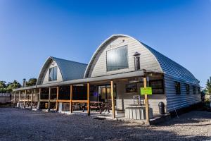 a building with a gambrel roof with a sign on it at Arch Cabins Self Catering Homes Storms River in Stormsrivier