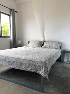 a bed in a white room with two pillows at Casa Palmeira in Lazareto