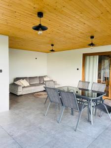 a living room with a table and chairs and a couch at Domek nad stawem RODOS in Raków +23 photos