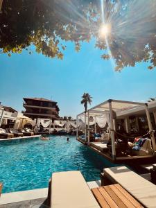 a pool with chaise lounges in a resort at Hotel Afrodite in Nei Poroi