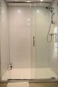 y baño con ducha y puerta de cristal. en ALTIDO Charming 3 bed flat in Haymarket, private parking and patio, en Edimburgo
