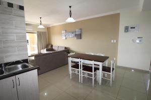 een keuken en een woonkamer met een tafel en een bank bij Saints View Resort Unit 8 in Uvongo Beach