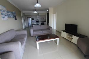 a living room with a couch and a tv at Saints View Resort Unit 8 in Uvongo Beach