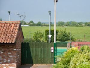 a building with a fence and a gate with a train at The Chestnuts Holiday Cottages in Burgh le Marsh +21 photos