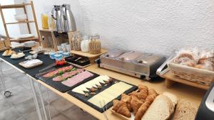 un tavolo con pane e altri prodotti alimentari su di esso di Hostal Residencia Alma a Port d'Alcudia