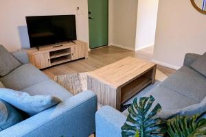 a living room with two couches and a flat screen tv at Relaxing Home Close to Nature in Bunbury