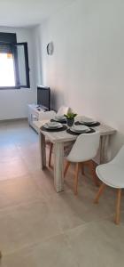 uma mesa de madeira com pratos e tigelas numa sala em Apartamentos Tarifa Sun em Tarifa