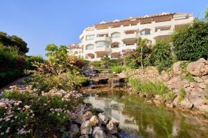 ein Hotel mit einem Bach vor einem Gebäude in der Unterkunft Marbella SunCity in Marbella