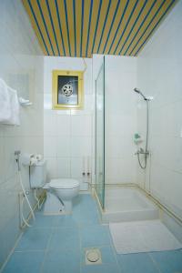 a bathroom with a shower and a toilet and a sink at La Villa Hotel in Doha