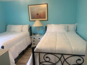 two beds sitting next to each other in a bedroom at Cheerful two bedroom house 1.5 miles from beach. in Myrtle Beach