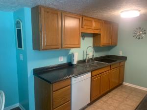 a kitchen with wooden cabinets and a sink at Cheerful two bedroom house 1.5 miles from beach. in Myrtle Beach
