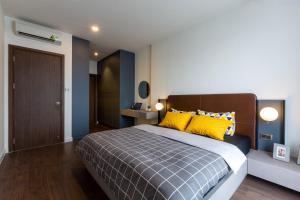 - une chambre avec un grand lit et des oreillers jaunes dans l'établissement Oui! Oui! CBD Apartment - Rivergate Building, à Hô-Chi-Minh-Ville