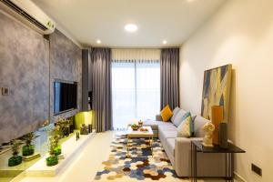 a living room with a couch and a tv at Oui! Oui! CBD Apartment - Rivergate Building in Ho Chi Minh City