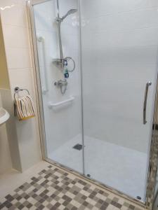 a shower with a glass door in a bathroom at Fishermans Cottage in Killough