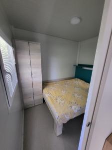 a small bedroom with a bed and cabinets at Kamp Katra Mobilna hiška ECO in Vinica