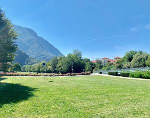 a grass field with a mountain in the background at Appartamento Bolzano Centro Talvera in Bolzano