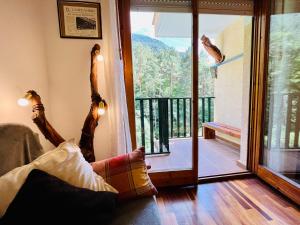 a person laying on a couch looking out of a window at El refugio de la ardilla, apartamento Canfranc-estacion in Canfranc-Estación +47 photos