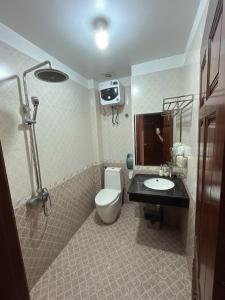 a bathroom with a toilet and a sink at Khách Sạn Nam Sơn in Ðông Khê