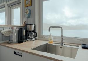 a kitchen counter with a sink and a window at Cozy 2-bedroom house with a fantastic view in Leynar