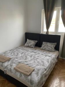 a bed with two pillows on it in a bedroom at Apartmani Home in Zaječar