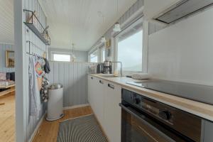 a kitchen with a sink and a stove at Cozy 2-bedroom house with a fantastic view in Leynar