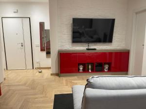 un soggiorno con TV su un centro di intrattenimento rosso di Suite San Paolo Tv Cinema a Roma