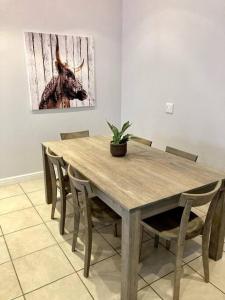 a wooden table with chairs and a picture of a cow at Kingswood Gardens No. 4 in George
