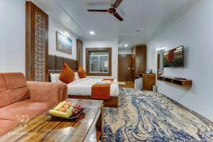 una habitación de hotel con una cama y un sofá en KAREEM RESIDENCY, en Srinagar