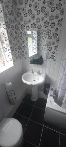 a bathroom with a white sink and a toilet at 6-min Walk to New Cross Parking Long Stay Discounts in Fallings Park