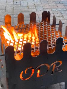 a fire in a metal grill with flames at luxury railway carriage with stunning views in Hereford