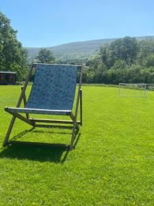 uma cadeira azul sentada num campo de relva em luxury railway carriage with stunning views em Hereford