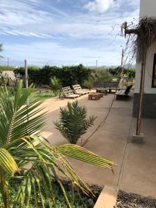 eine Terrasse mit Stühlen, Tischen und einer Bank in der Unterkunft Casa Palmeira in Lazareto