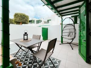 a patio with a table and chairs and a swing at Apartamento Maëlle Playa Blanca in Playa Blanca