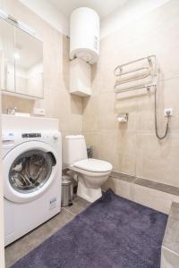 a bathroom with a washing machine and a toilet at Valdemara Design Studio Apartment in City Center in Rīga