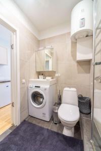 a bathroom with a toilet and a washing machine at Valdemara Design Studio Apartment in City Center in Rīga