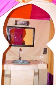 a bathroom with a sink and a mirror at Les Roches Desert Camp in Merzouga